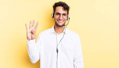 İspanyol yakışıklı adam gülümsüyor ve arkadaş canlısı görünüyor, dört numarayı gösteriyor. tele pazarlamacı konsepti