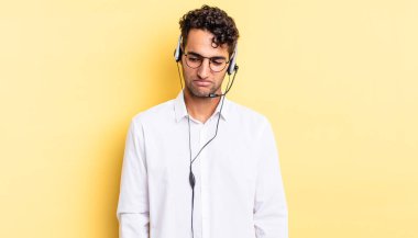 Hispanik yakışıklı adam üzgün, üzgün ya da kızgın hissediyor ve yana bakıyor. tele pazarlamacı konsepti