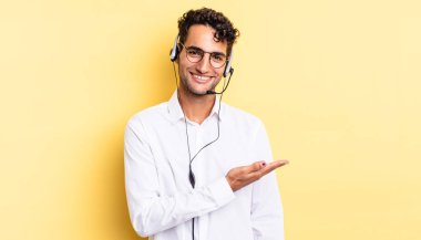 İspanyol yakışıklı adam neşeyle gülümsüyor, mutlu hissediyor ve bir konsept gösteriyor. tele pazarlamacı konsepti