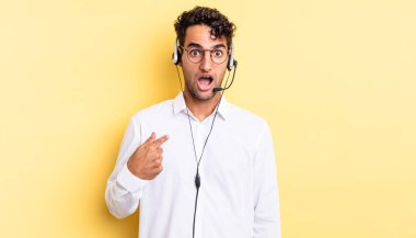 İspanyol yakışıklı adam şok olmuş ve ağzı açık, kendini işaret ederek şaşırmış görünüyor. tele pazarlamacı konsepti