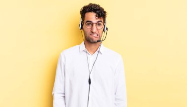 İspanyol yakışıklı adam kafası karışmış ve şaşkın görünüyor. tele pazarlamacı konsepti