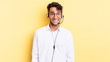 İspanyol yakışıklı adam mutlu ve hoş bir şekilde şaşırmış görünüyor. tele pazarlamacı konsepti