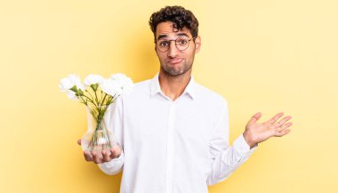 İspanyol yakışıklı adam şaşkın, şaşkın ve şüpheci hissediyor. çiçek saksı konsepti