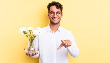 İspanyol yakışıklı adam kamerayı göstererek seni seçiyor. çiçek saksı konsepti