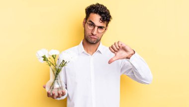Latin asıllı yakışıklı adam kızgın, baş parmağını kaldırıyor. çiçek saksı konsepti