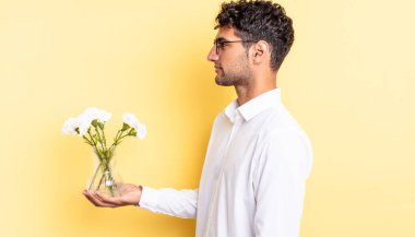 Profil görünümlü İspanyol yakışıklı adam hayal mi kuruyor, hayal mi kuruyor, hayal mi kuruyor? çiçek saksı konsepti