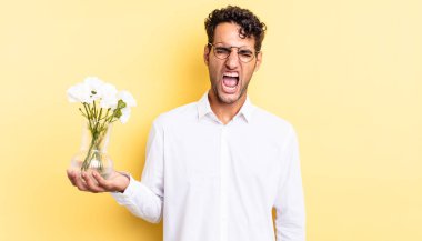 İspanyol yakışıklı adam agresif bir şekilde bağırıyor, çok kızgın görünüyor. çiçek saksı konsepti
