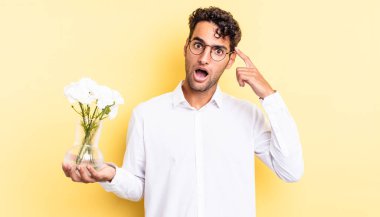 İspanyol yakışıklı adam şaşırmış görünüyor, yeni bir düşünce, fikir ya da konsept fark ediyor. çiçek saksı konsepti