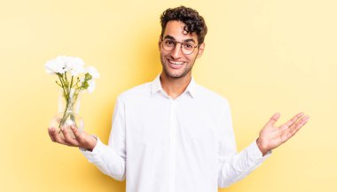 İspanyol yakışıklı adam kendini mutlu hissediyor, bir çözüm ya da fikir bulduğuna şaşırıyor. çiçek saksı konsepti