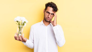 İspanyol yakışıklı bir adam yorgun, bıkkın ve uykulu hissediyor. çiçek saksı konsepti