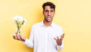 İspanyol yakışıklı adam umutsuz, sinirli ve stresli görünüyor. çiçek saksı konsepti