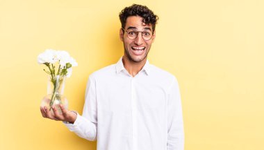 İspanyol yakışıklı adam mutlu ve hoş bir şekilde şaşırmış görünüyor. çiçek saksı konsepti
