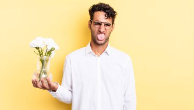 İspanyol yakışıklı adam iğreniyor, sinirleniyor ve dili dışarı çıkıyor. çiçek saksı konsepti