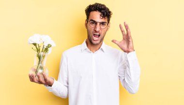 İspanyol yakışıklı adam ellerini havaya kaldırarak bağırıyor. çiçek saksı konsepti