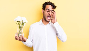 İspanyol yakışıklı adam mutlu, heyecanlı ve şaşırmış hissediyor. çiçek saksı konsepti