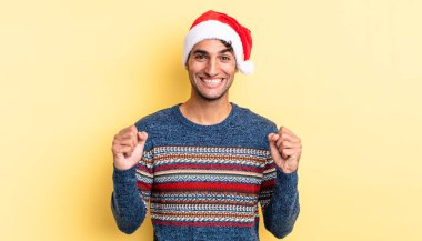 İspanyol yakışıklı adam şokta, gülüyor ve başarıyı kutluyor. Noel konsepti