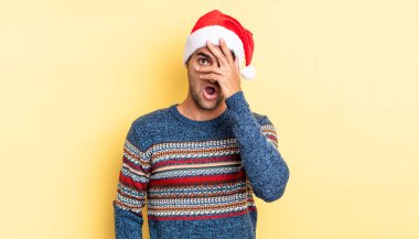 İspanyol yakışıklı adam şok olmuş, korkmuş ya da korkmuş görünüyor. Yüzü elle kapatılmış. Noel konsepti