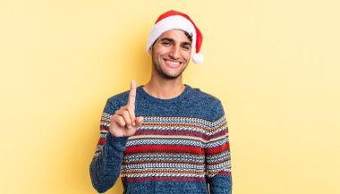 Hispanik yakışıklı adam gururla gülümsüyor ve kendinden emin bir numara oluyor. Noel konsepti