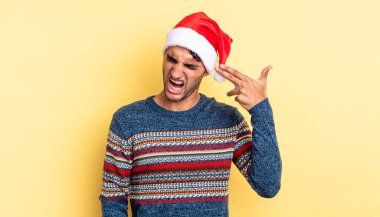 İspanyol yakışıklı adam mutsuz ve stresli görünüyor, intihar jesti silah işareti yapıyor. Noel konsepti