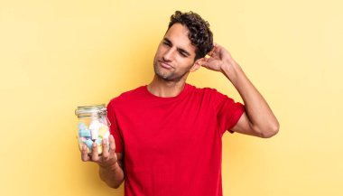 İspanyol yakışıklı adam mutlu bir şekilde gülümsüyor ve hayal kuruyor ya da şüphe ediyor. şeker konsepti