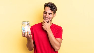 Mutlu, kendine güvenen, elleri çenesinde gülümseyen İspanyol yakışıklı bir adam. şeker konsepti