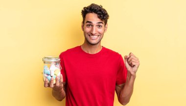 İspanyol yakışıklı adam şokta, gülüyor ve başarıyı kutluyor. şeker konsepti