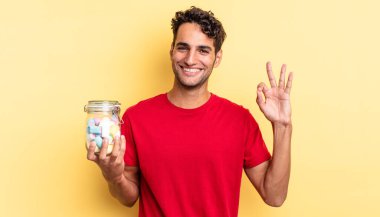 İspanyol yakışıklı adam kendini mutlu hissediyor, iyi bir jestle onaylıyor. şeker konsepti