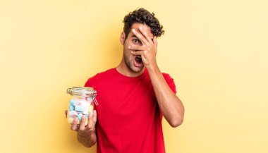 İspanyol yakışıklı adam şok olmuş, korkmuş ya da korkmuş görünüyor. Yüzü elle kapatılmış. şeker konsepti