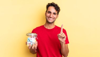 Hispanik yakışıklı adam gururla gülümsüyor ve kendinden emin bir numara oluyor. şeker konsepti