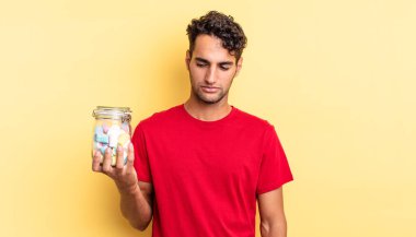 Hispanik yakışıklı adam üzgün, üzgün ya da kızgın hissediyor ve yana bakıyor. şeker konsepti