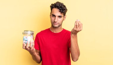 İspanyol yakışıklı adam kapiş ya da para hareketi yapıyor, sana ödemeni söylüyor. şeker konsepti