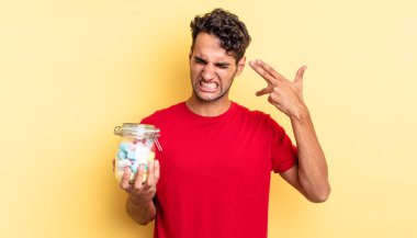 İspanyol yakışıklı adam mutsuz ve stresli görünüyor, intihar jesti silah işareti yapıyor. şeker konsepti