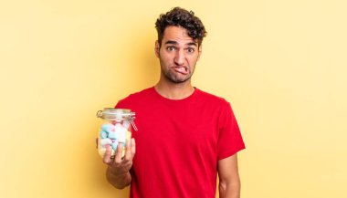 İspanyol yakışıklı adam kafası karışmış ve şaşkın görünüyor. şeker konsepti