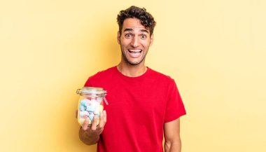 İspanyol yakışıklı adam mutlu ve hoş bir şekilde şaşırmış görünüyor. şeker konsepti