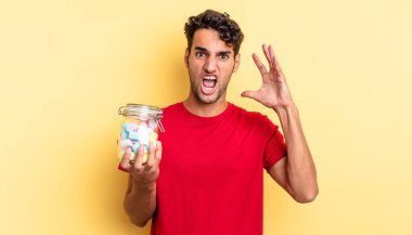 İspanyol yakışıklı adam ellerini havaya kaldırarak bağırıyor. şeker konsepti