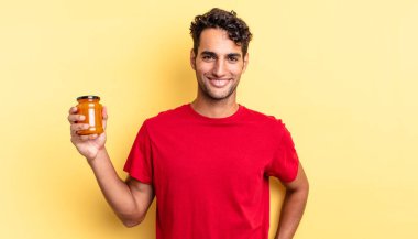 İspanyol yakışıklı adam mutlu bir şekilde gülümsüyor, eli kalçasında ve kendinden emin. Şeftali reçeli