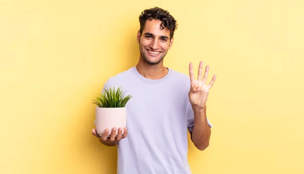 Spaanstalige Knappe Man Lachend Vriendelijk Toont Nummer Vier Decoratieve Plant — Stockfoto