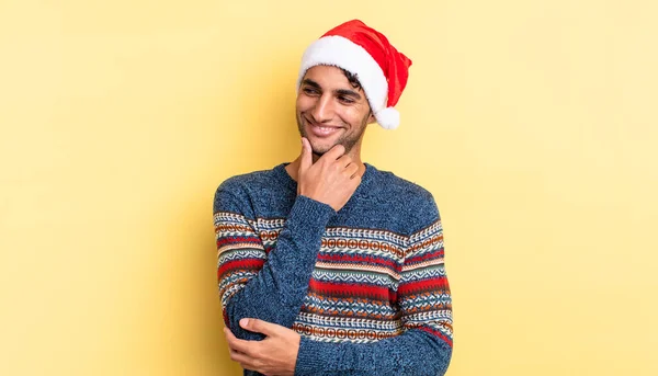 ヒスパニックハンサムな男は幸せな自信を持って笑顔で顎に手で表現します クリスマスのコンセプト — ストック写真