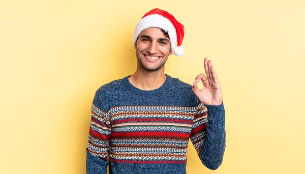 İspanyol yakışıklı adam kendini mutlu hissediyor, iyi bir jestle onaylıyor. Noel konsepti