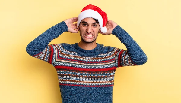 ヒスパニック系のハンサムな男は 頭の上に手で 不安や怖がって ストレスを感じる クリスマスのコンセプト — ストック写真