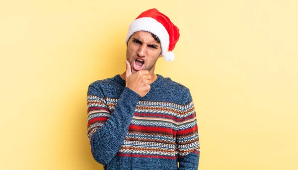 口と目を大きく開いて顎を手に持つパニックハンサムな男 クリスマスのコンセプト — ストック写真