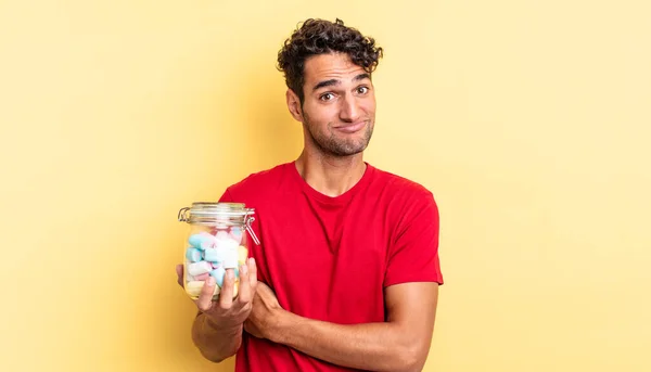 Hispanic Handsome Man Shrugging Feeling Confused Uncertain Candies Concept — Stock Photo, Image