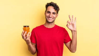 İspanyol yakışıklı adam kendini mutlu hissediyor, iyi bir jestle onaylıyor. Şeftali reçeli