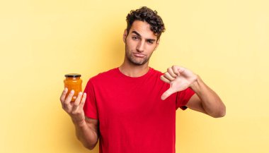 Latin asıllı yakışıklı adam kızgın, baş parmağını kaldırıyor. Şeftali reçeli