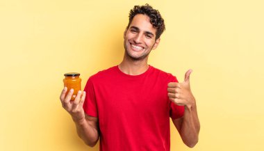 İspanyol yakışıklı adam kendini gururlu hissediyor, başparmağıyla olumlu gülümsüyor. Şeftali reçeli