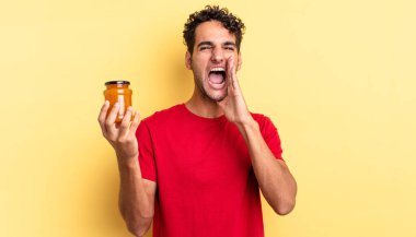 İspanyol yakışıklı adam kendini mutlu hissediyor, elleri ağızının yanında bağırıyor. Şeftali reçeli