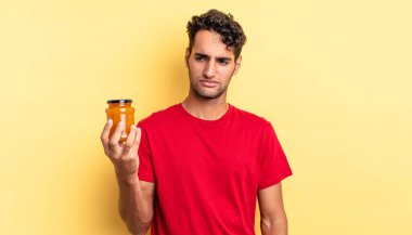 Hispanik yakışıklı adam üzgün, üzgün ya da kızgın hissediyor ve yana bakıyor. Şeftali reçeli