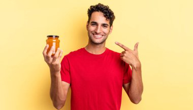 İspanyol yakışıklı adam kendine güvenerek gülüyor ve kendi gülüşüne işaret ediyor. Şeftali reçeli