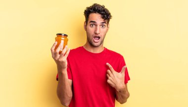 İspanyol yakışıklı adam şok olmuş ve ağzı açık, kendini işaret ederek şaşırmış görünüyor. Şeftali reçeli