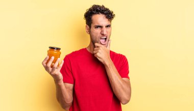 Ağzı ve gözleri açık, eli çenesinde İspanyol yakışıklı bir adam. Şeftali reçeli